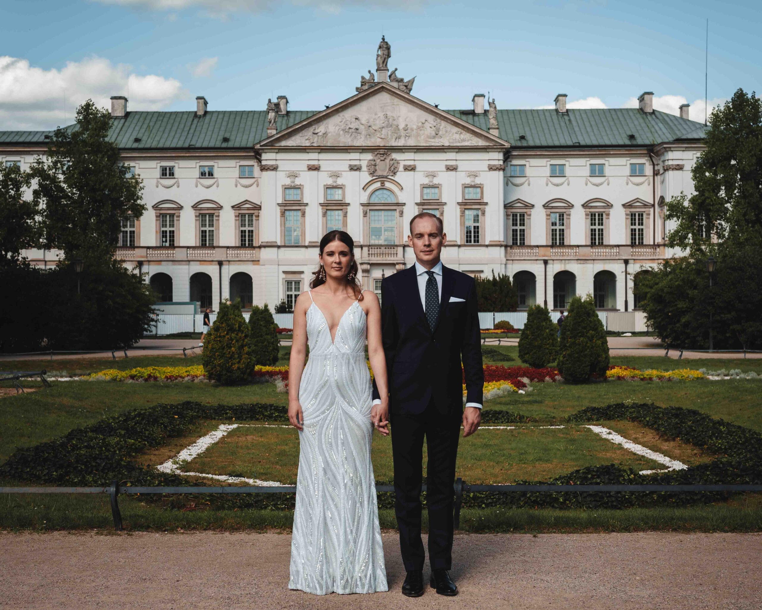 Para Młoda w parku na tle pięknego pałacu.