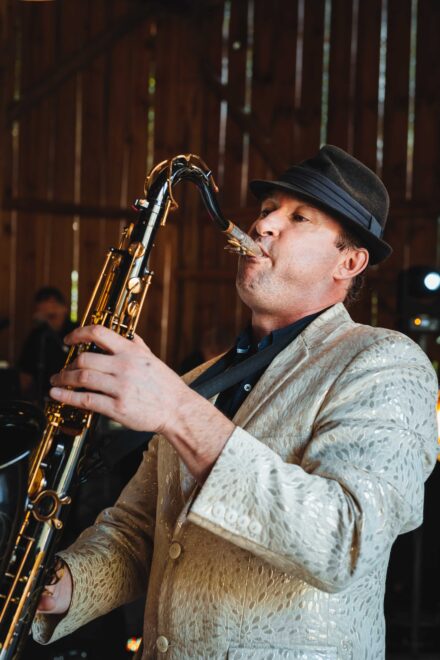 Saksofonista gra w stodole.