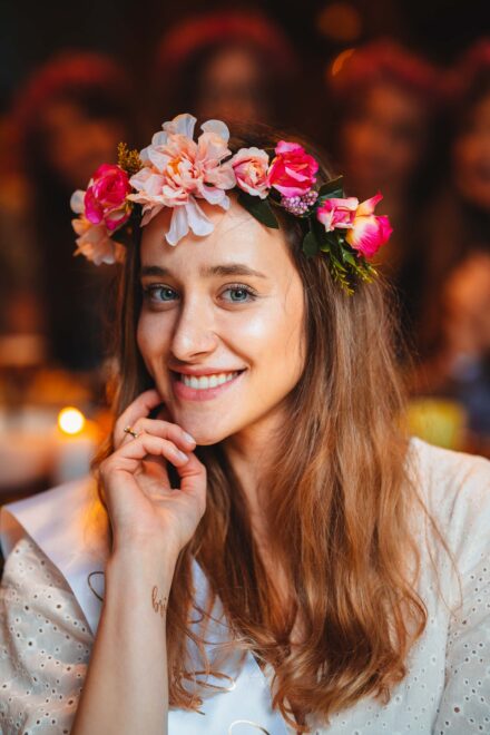 Portret Panny Młodej, która się uśmiecha i ma zielono-niebieskie oczy.