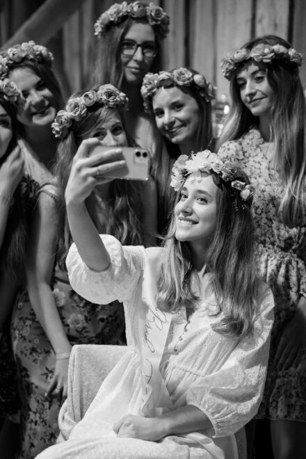 Panna Młoda robi "selfie" telefonem komórkowym sobie i swoim przyjaciółkom.