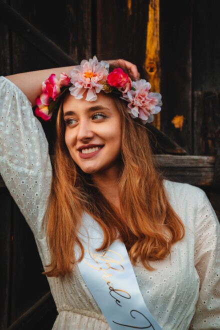 Portret Panny Młodej z szarfą "bride to be" oraz wiankiem z kwiatów.