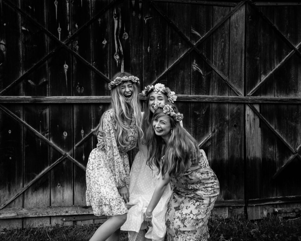 Druhny na tle drewnianych drzwi bardzo się śmieją i dobrze bawią w trakcie wieczoru panieńskiego.