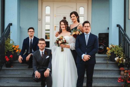 Zdjęcie grupowe najbliższej rodziny Panny Młodej i Pana Młodego. Wszyscy pozują na schodach przed domem Panny Młodej.